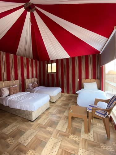 two beds in a room with a red ceiling at Wadi rum Gory camp in Disah