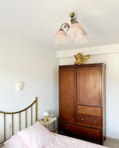 a bedroom with a bed and a wooden dresser at El Violetu in Cue
