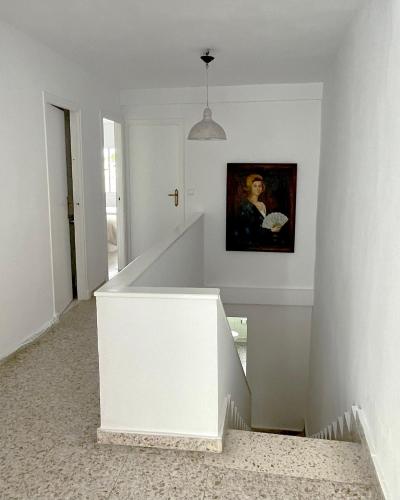a white staircase with a painting on the wall at El Violetu in Cue