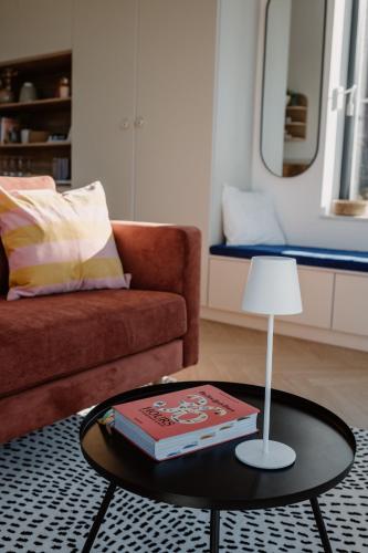 a living room with a couch and a table with a lamp at SUQO vendégház in Sukoró
