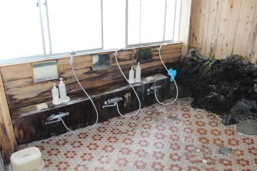 a dirty bathroom with pipes and sinks in a room at Kinokuniya Ryokan in Fujisawa
