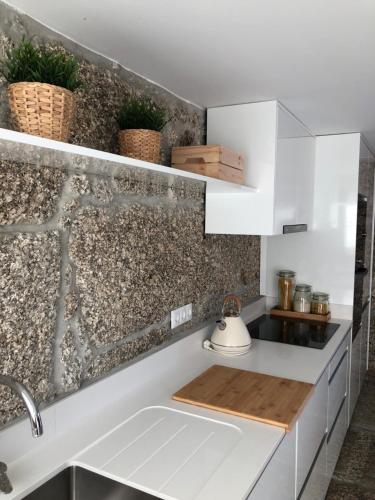 eine Küche mit weißen Schränken und einem Waschbecken in der Unterkunft Sobreiro Valley - Casa Isabel in Vieira do Minho