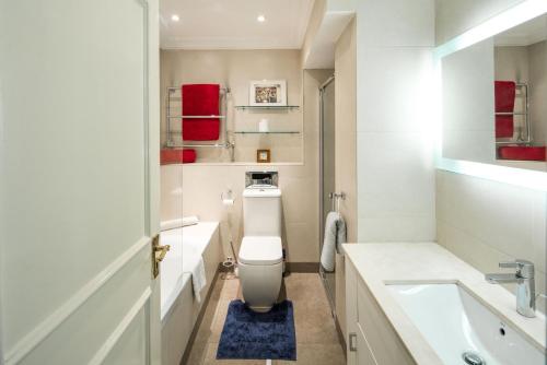 a white bathroom with a toilet and a sink at Elegant 2-Bed Duplex with Patio nr Battersea Park in London