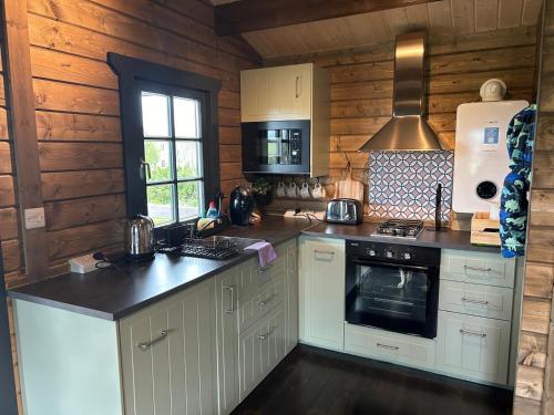 a kitchen with white cabinets and a stove top oven at Little Rock Retreat in Westmeath