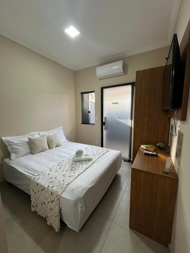 a bedroom with a large bed and a television at Casa Lua Flat in Brumadinho