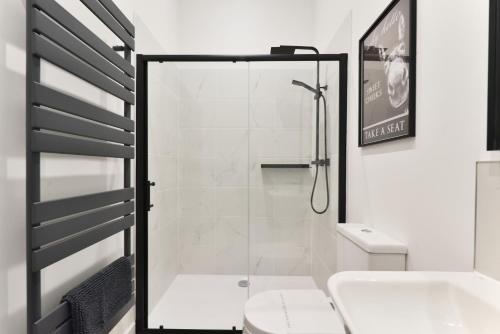 een badkamer met een douche, een toilet en een wastafel bij Apt 3, 15 West Street in Hereford