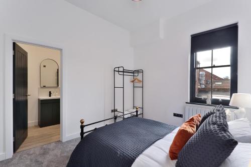 a bedroom with a black and white bed and a bathroom at Apt 3, 15 West Street in Hereford