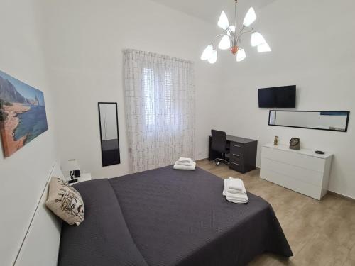 1 dormitorio con cama negra y TV en Abitazione Del Mandorlo, en Trapani