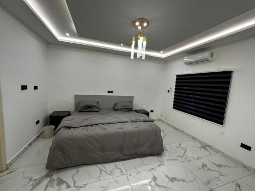 a bedroom with a bed in a white room at Bobby’s villa in Accra