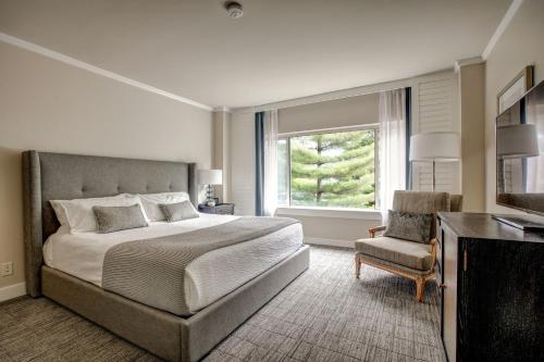 a bedroom with a bed and a chair and a window at Woodmark Hotel & Still Spa in Kirkland