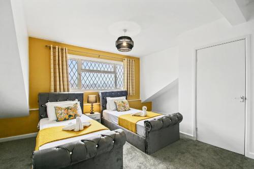 a bedroom with two beds and a couch at Home In Woodhouse, Leeds in Leeds