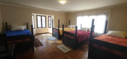 a bedroom with two beds and a window at Raven La Paz in La Paz
