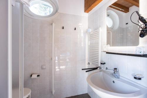 a bathroom with a sink and a tub and a window at Albergo Del Sole in Varenna