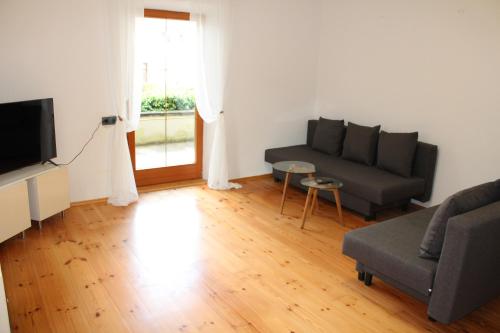 a living room with a couch and a tv at Haus & Garten bis zu 6 Personen! in Rosenheim