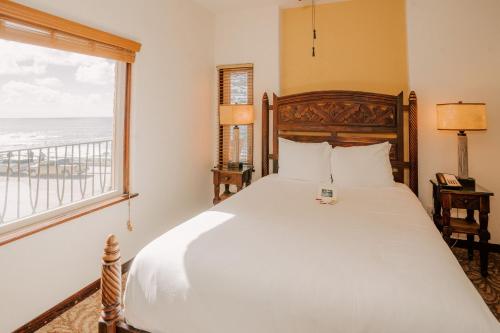 a bedroom with a large bed with a view of the ocean at Pantai Inn in San Diego