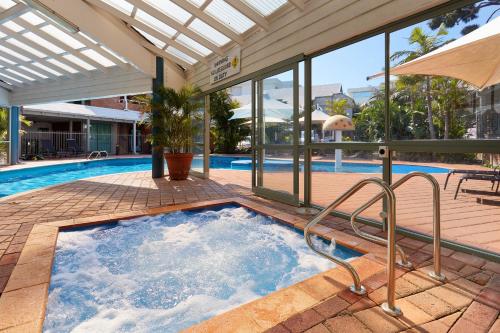 a pool with a pool table and a pool tub at Broadwater Resort Como in Perth
