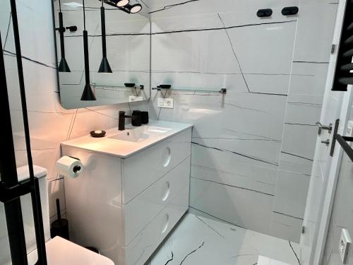 une salle de bain blanche avec un lavabo et un miroir dans l'établissement Casa Refa en Cabo Roig, à Orihuela Costa