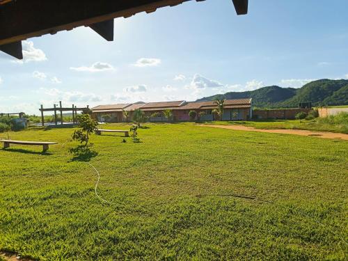 ein Feld mit zwei Bänken vor einem Gebäude in der Unterkunft Pousada Horizonte por do sol in Nobres