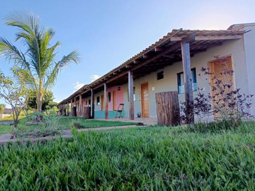 una fila de casas con una palmera delante en Pousada Horizonte por do sol, en Nobres