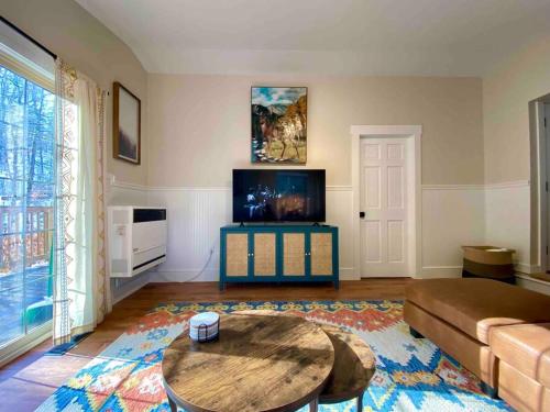 a living room with a couch and a table at Jewel Brook Cottage in Ludlow