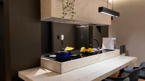 a kitchen with a counter with a stove top oven at Apartamento Terracota in Piumhi