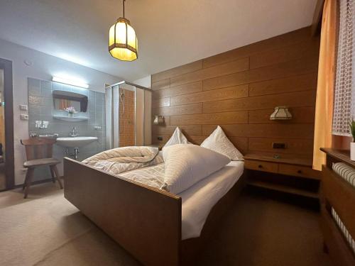 1 dormitorio con 1 cama y lavamanos en una habitación en Dorfwirt en Mils bei Imst