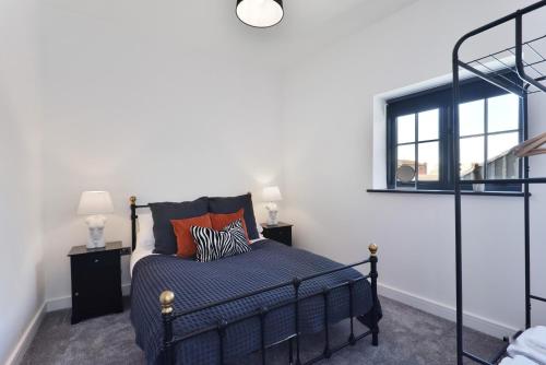 a bedroom with a black bed and a window at Apt 1, 15 West Street in Hereford