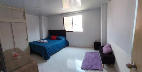 um quarto com uma cama azul e uma janela em HABITACIÓN PRIVADA tranquila y confortable em Bello