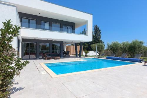 une villa avec une piscine en face d'une maison dans l'établissement Ferienhaus mit Privatpool für 10 Personen ca 308 qm in Banjole, Istrien Istrische Riviera, à Banjole