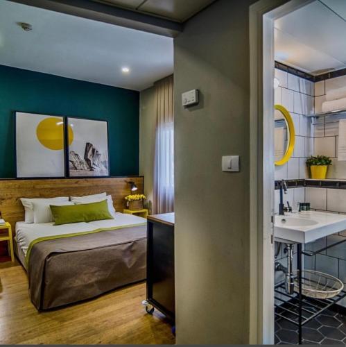 ein Schlafzimmer mit einem Bett und einem Waschbecken in der Unterkunft Just Like Hotel in Tel Aviv
