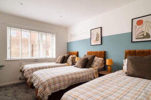 Duas camas num quarto com paredes azuis em Contractor Base Sleeps 7, Pool Table & PS4 em Gillingham