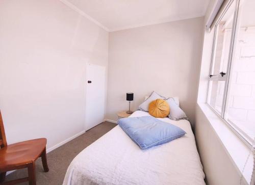 a small bedroom with a bed and a window at A modern 2 bedroom with private backyard, kitchen. in Lower Hutt