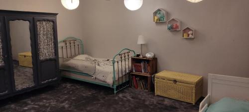 une chambre avec un lit et un miroir dans l'établissement Retrouvez votre famille ou vos amis au calme, à Aigueperse