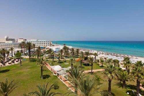 a view of a beach with palm trees and a resort at El Mehdi Beach Resort ex Primasol El Mehdi in Mahdia