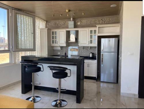 a kitchen with a black counter and a refrigerator at 1BR-Deir Gbar rooftop in Amman