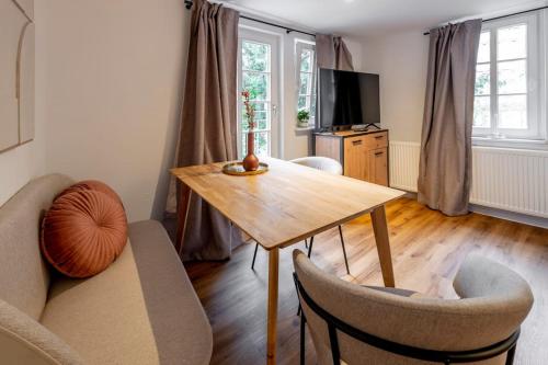 Himmlische Altstadt-Maisonette في ماربورغ ان دير لان: غرفة معيشة مع طاولة وكراسي خشبية