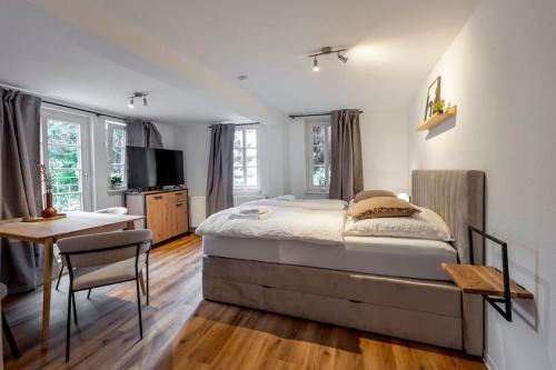 a bedroom with a bed and a desk and a television at Himmlische Altstadt-Maisonette in Marburg an der Lahn