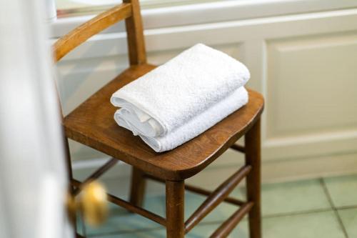una pila de toallas sentadas en una silla de madera en Westerpark Countryside Cottage en Huntly