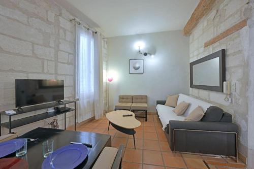 un salon avec un canapé et une télévision dans l'établissement Cuore di Carmes - Navette parking GRATUIT - Climatisé, à Avignon