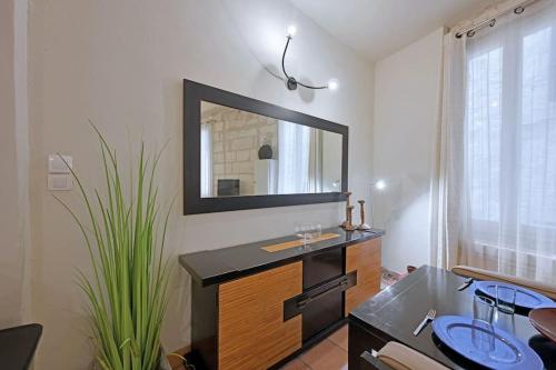 une salle de bain avec un lavabo et un miroir sur un mur dans l'établissement Cuore di Carmes - Navette parking GRATUIT - Climatisé, à Avignon