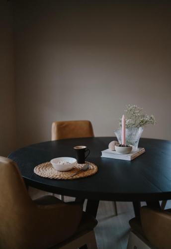 een zwarte tafel met twee kopjes en een kaars erop bij Hus på Valderøya in Valderhaug