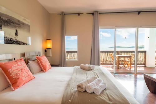 a bedroom with a large bed with towels on it at Les Villas du Lagon in Le François
