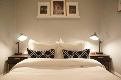 1 dormitorio con 1 cama blanca grande y 2 lámparas en Cozy Nest in Chicago's Vibrant Lincoln Square, en Chicago