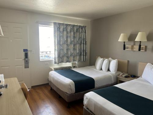 um quarto de hotel com duas camas e uma janela em Motel 6-Stanton, CA em Stanton