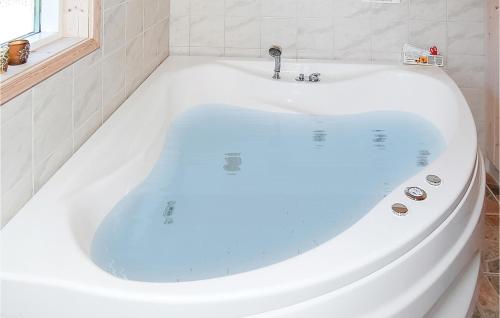 a white bath tub in a bathroom with a window at Holiday Home Råde Strandpark Ix in Årøsund