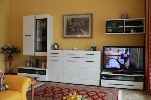 a living room with a tv and a white cabinet at Casa Roccia in Pino Lago Maggiore