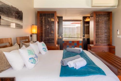 a bedroom with a large white bed with white pillows at Les Villas du Lagon in Le François