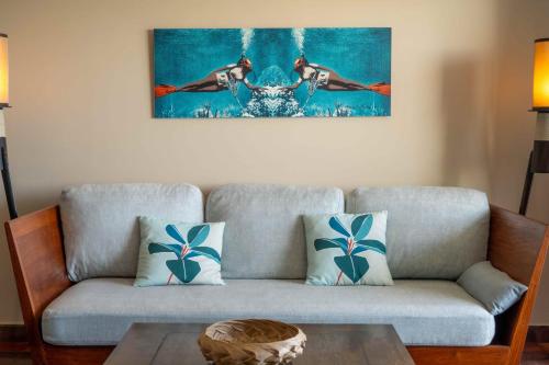 a living room with a couch and a painting on the wall at Les Villas du Lagon in Le François