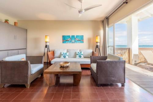 a living room with a couch and chairs and a table at Les Villas du Lagon in Le François