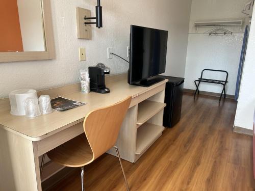 a desk with a television on top of it in a room at Motel 6-Stanton, CA- Anaheim West in Stanton